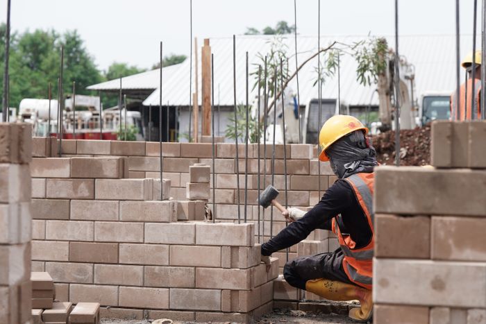 PERMINTAAN DOMESTIK: Proses pemasangan produk turunan semen hijau SIG bata interlock presisi untuk pembangunan rumah contoh di kawasan Bambu Apus, Jakarta Timur.