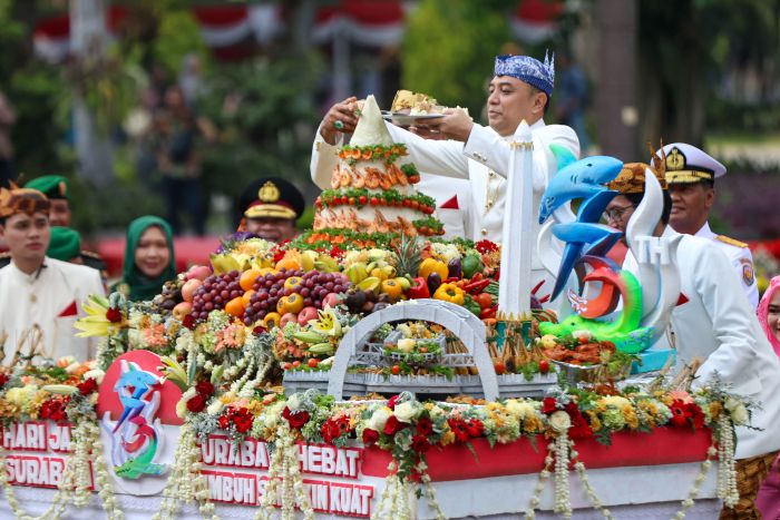 SELAMAT: Wali Kota Surabaya Eri Cahyadi memotong tumpeng dalam rangka resepsi HJKS ke-732 di halaman Balai Kota Surabaya, Sabtu (31/5/2025).