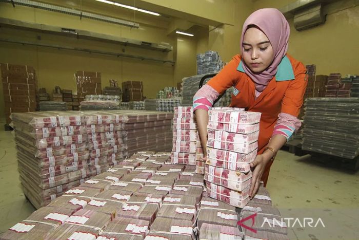 SIBUK: Petugas menata tumpukan uang kertas rupiah saat melakukan persiapan pengisian ATM