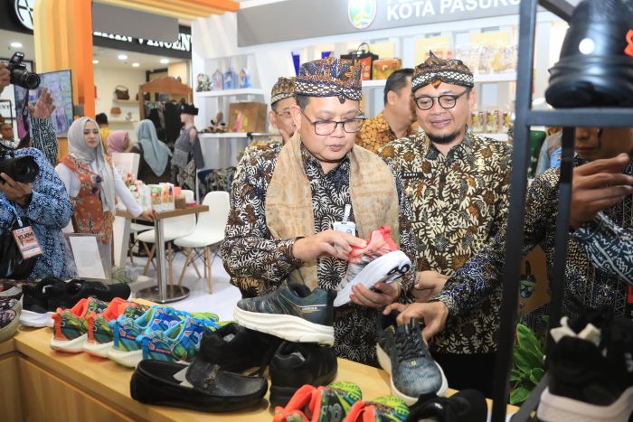 PILIH: Sekdaprov Jatim Adhy Karyono melihat sepatu di salah satu stan peserta Koperasi dan UMKM (KUKM) Expo ke-12 tahun 2025 yang digelar di Atrium Royal Plaza Surabaya, Kamis (31/7/2025).
