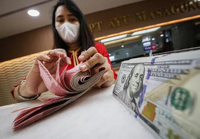 HITUNG: Seorang karyawan menghitung rupiah yng k ditukarkn dengan dolar Amerika Serikat di salah satu money changer.