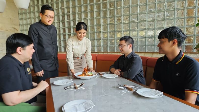 SAJI: Jimmy Irawan bersama karyawan mengantarkan menu unggulan kepiting Caramelized Butter Crab pada pelanggan saat pembukaan Crab n Co di CitraLand Surabaya.