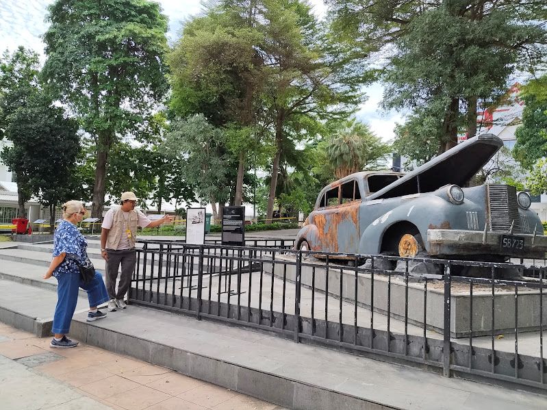 KUNJUNGAN: Salah satu wisman mendapat penjelasan dari guide saat mengunjungi replika mobil Mallaby di Kawasan Kota Lama Surabaya.