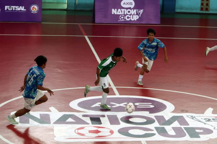 FUTSAL PELAJAR: Pemain dari tim futsal SMKN 12 dan SMAN 9 Surabaya, berebut bola dalam turnamen futsal AXIS Nation Cup 2025, yang digelar di GOR Unesa, Minggu (14/9).