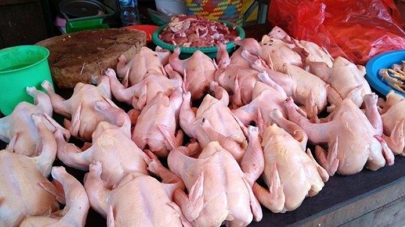 JUALAN: Daging ayam ditata di atas meja untuk dijual di sebuah pasar tradisional.