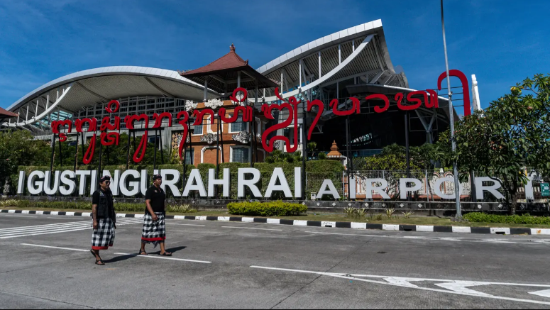 BUDAYA: Dua penjaga keamanan tradisional Bali, yang secara lokal dikenal sebagai Pecalang, melintas di luar Bandara Internasional Ngurah Rai di Badung.