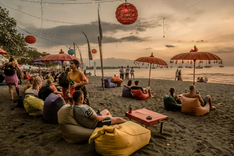 SANTAI: Wisatawan sedang menikmati suasana sore di salah satu pantai di Pulai Bali.