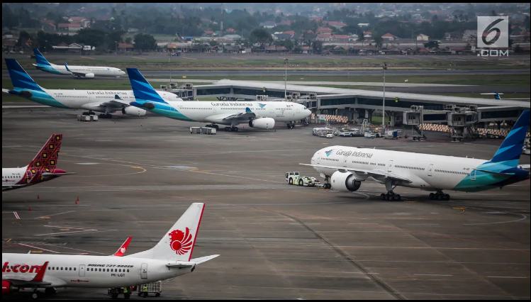 PARKIR: Aktivitas penerbangan di areal Bandara Soekarno Hatta, Tangerang, Banten. Tarif tiket pesawat Angkutan Nataru turun 14 persen.