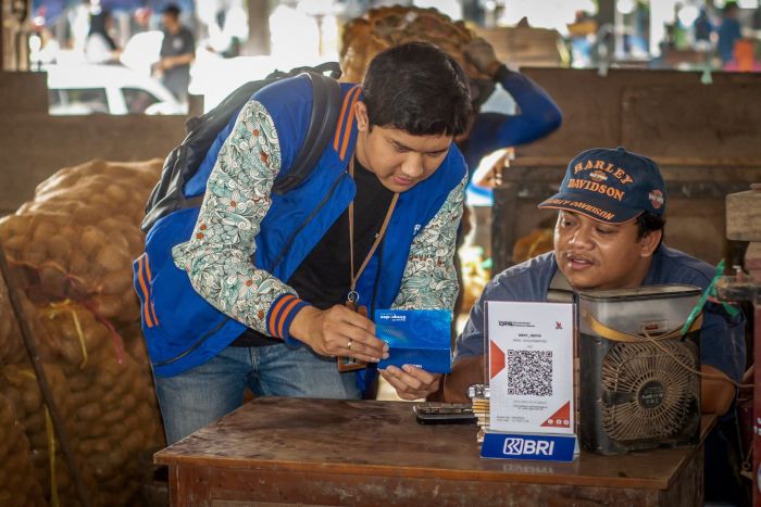 PENJELASAN: Salah satu pelaku UMKM mendapat penjelasan mengenai Kredit Usaha Rakyat (KUR) dari karyawan BRI.