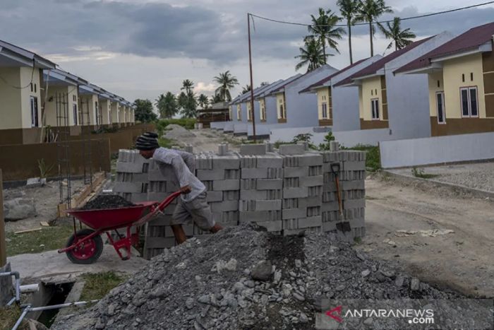 ANGKUT: Seorang pekerja mengangkut material bangunan. Rumah tapak menengah ke bawah atau rumah sederhana menjadi penopang kredit BTN.