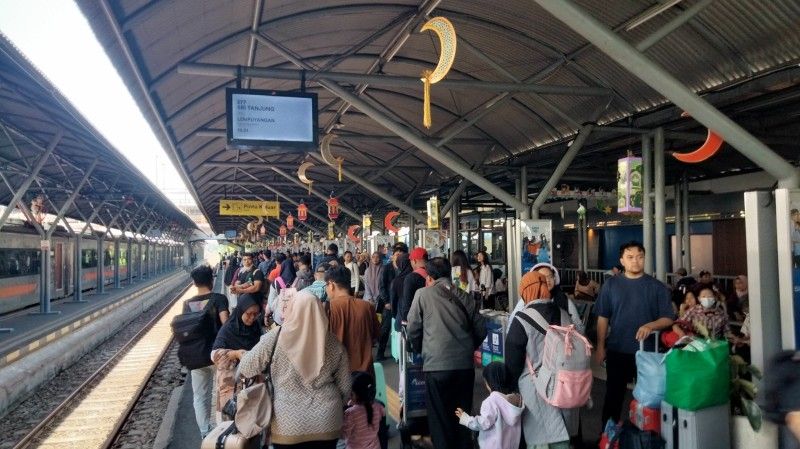 ANTRE: Penumpang antre menunggu kereta yang akan membawa mereka menuju ke tempat tujuan.
