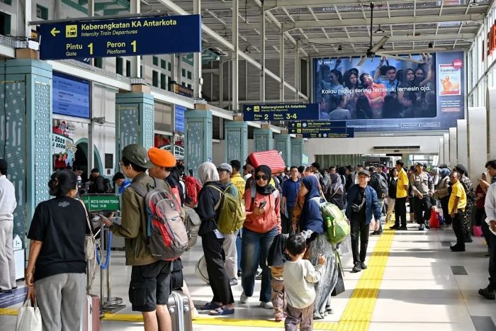 ANTRE: Sejumlah calon penumpang kereta api menunggu masuk ke stasiun untuk selanjutnya melakukan perjalanan dalam rangka libu Nataru.