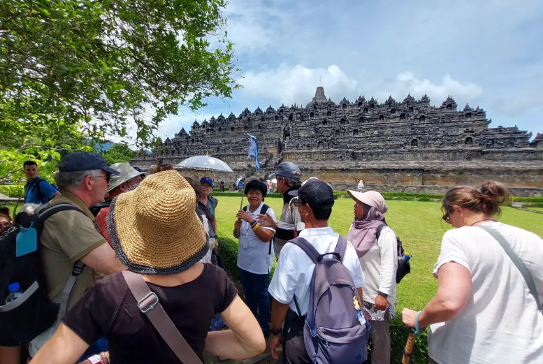 BERTEDUH: Sejumlah wisatawan asing bersama tour guide mereka, melakukan koordinasi sebelum menuju ke kawasan Taman Wisata Candi Borobudur di Magelang, Jawa Tengah.
