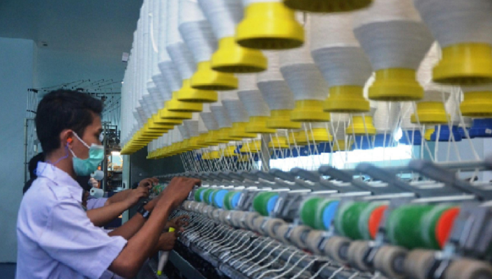 FOKUS: Pekerja mengamati jaringan benang di sebuah pabrik tekstil.