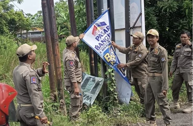 BONGKAR: Satuan Polisi Pamong Praja (Satpol PP) Kabupaten Gresik bergerak masif menertibkan ratusan reklame dan spanduk ilegal sebagai tindak lanjut atas instruksi Presiden Prabowo Subianto