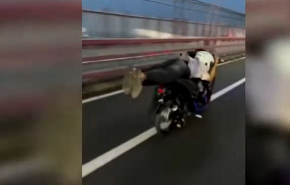 MELANGGAR: Aksi nekat di Jembatan Suramadu, pengendara terlihat melaju dengan kecepatan tinggi sambil berbaring di atas motor.