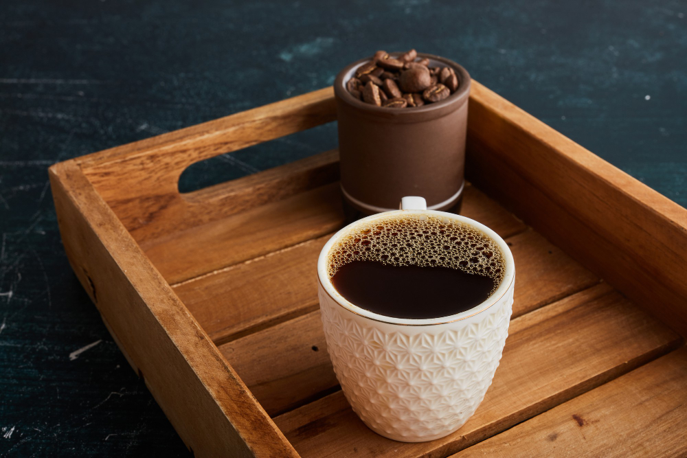Foto close-up secangkir espresso pekat dengan krema cokelat keemasan di atas meja kayu kedai kopi yang modern, menggambarkan tren gaya hidup produktif Gen Z.