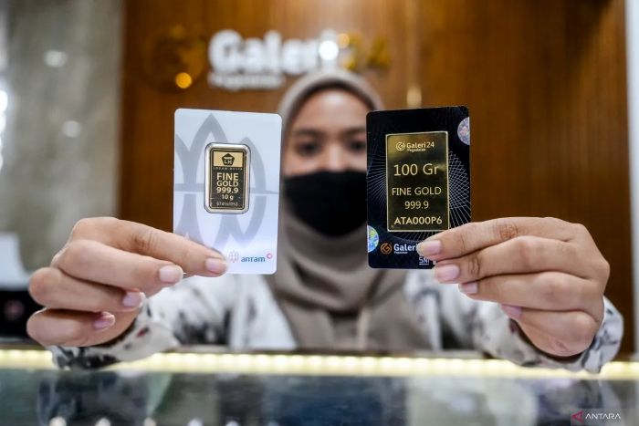  ILUSTRASI: Karyawan menunjukkan kepingan emas batangan yang ditawarkan di Pegadaian.