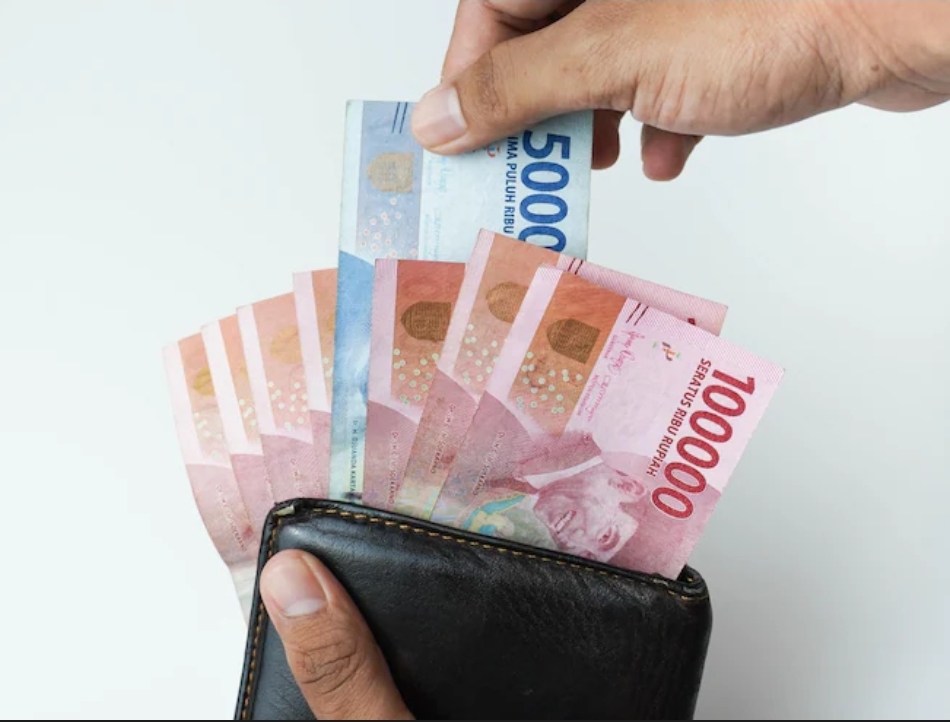 Ilustrasi: Lembaran uang Rupiah pecahan 100 ribu untuk THR 2026  karyawan dan ASN.