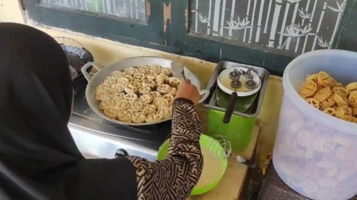 Seorang perajin saat melakukan proses penggorengan kue kembang goyang di rumah produksi