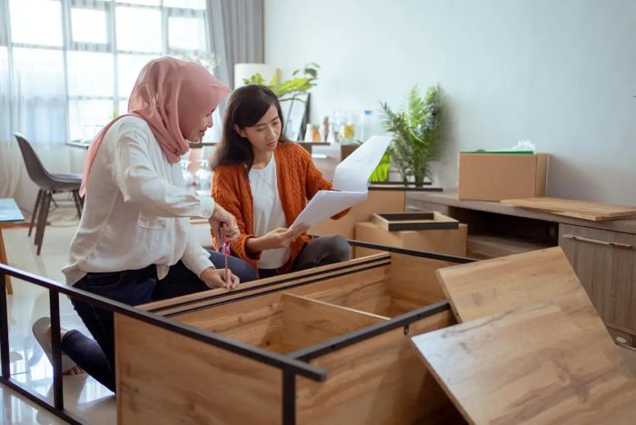 PRODUK LOKAL: Dua perempuan merakit furnitur knock down yang mereka beli. Subsektor furnitur mampu memberikan andil besar ke industri pengolahan nasional.