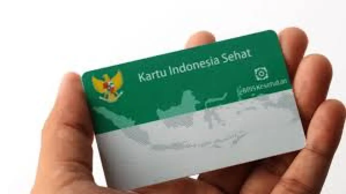 Seseorang memegang Kartu Indonesia Sehat (BPJS Kesehatan) sebagai simbol perlindungan kesehatan nasional di Indonesia.