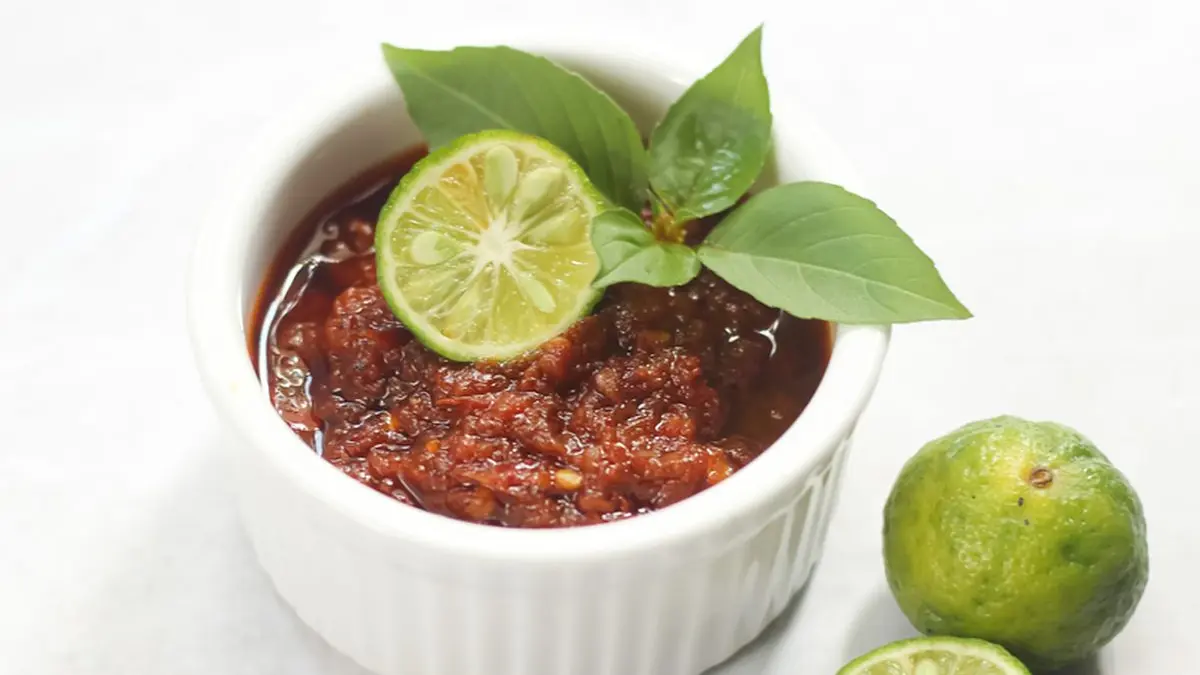 Foto close-up Sambal Bajak berwarna merah kecokelatan yang berminyak dan menggugah selera.