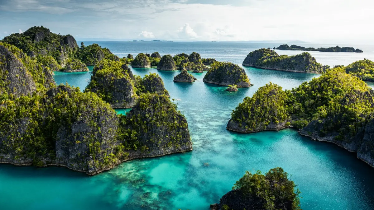 Panorama perairan Raja Ampat yang memukau, salah satu destinasi unggulan Indonesia yang masuk daftar 7 keajaiban Asia Tenggara 2026 versi Condé Nast Traveler