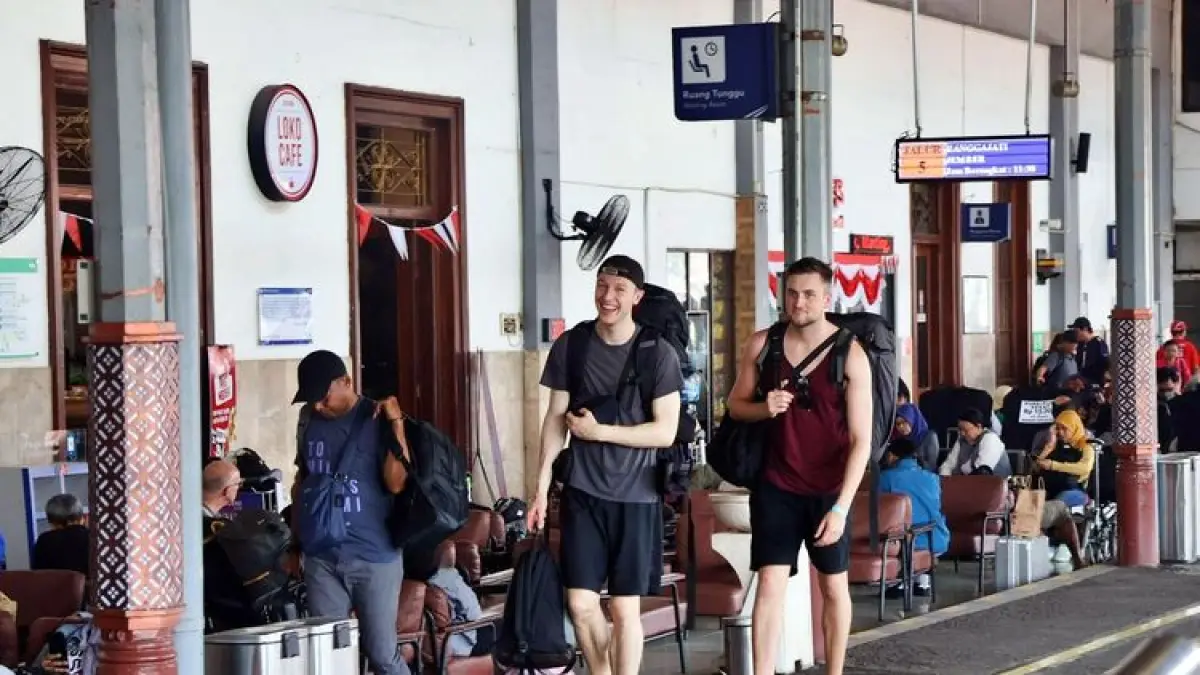 Wisatawan mancanegara sedang bersiap naik kereta api jarak jauh di peron stasiun.
