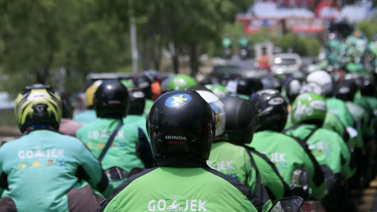 ILUSTRASI: Pengemudi ojek online beraktivitas di jalanan, seiring kebijakan baru pemerintah yang mengatur pembagian pendapatan dan perlindungan kerja bagi pekerja transportasi digital. (Foto: Kompas)