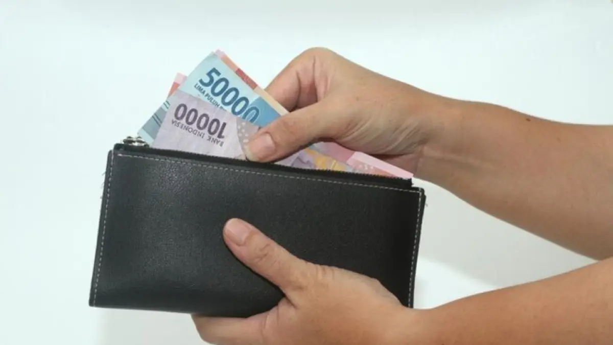 ILUSTRASI: Seorang warga menunjukkan uang pecahan Rupiah dari dalam dompetnya di Jakarta.