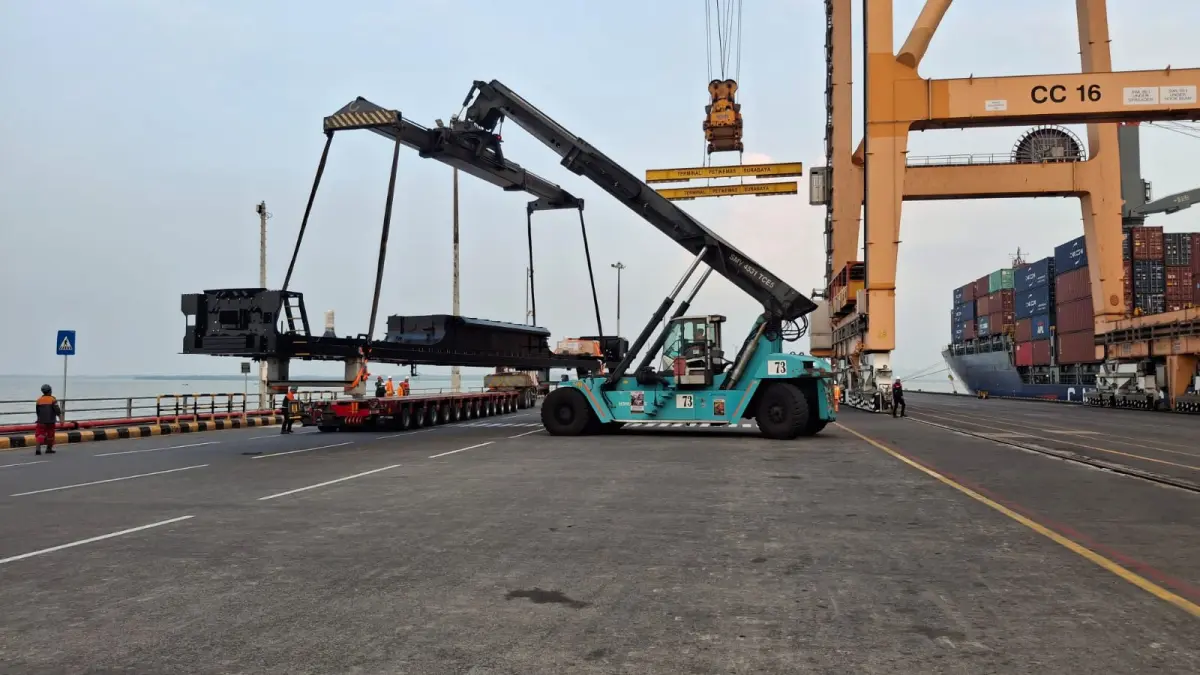 Pemuatan locomotive platform produksi PT INKA ke atas trailer menggunakan alat berat di Terminal Petikemas Surabaya (TPS) untuk diekspor menuju Australia, Minggu (24/05/2026).