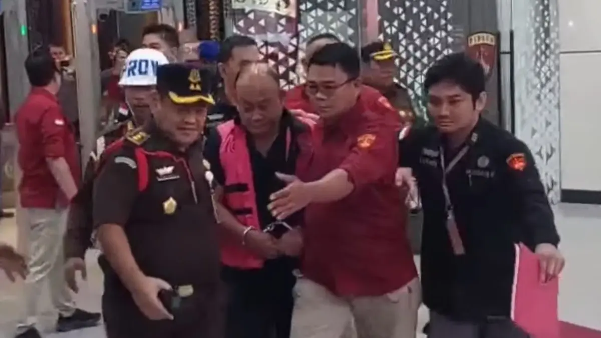 DITAHAN: Mantan Kepala Badan Gizi Nasional (BGN), Dadan Hindayana, terlihat mengenakan rompi tahanan berwarna merah muda dan tangan di borgol.