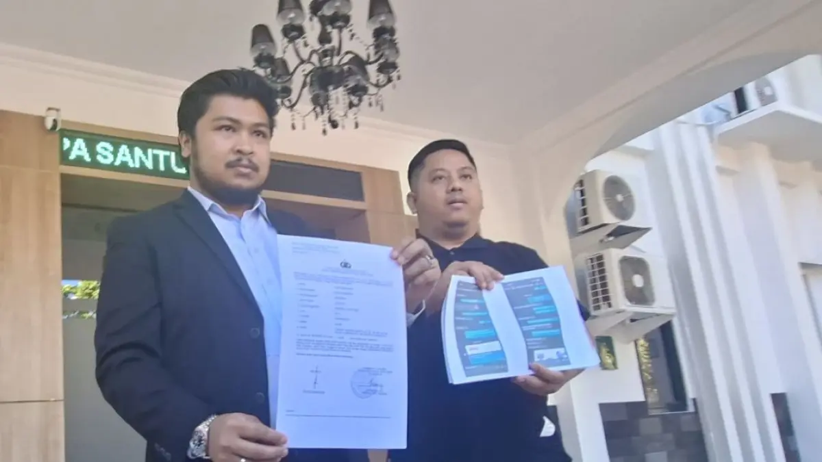 LAPOR: Kuasa hukum korban Descha (kiri) bersama korban Fajar menunjukkan laporan polisi kasus dugaan penipuan pembelian audio di Genteng, Surabaya. 
