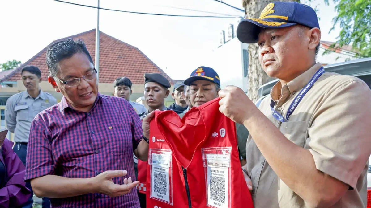 Pemkot Surabaya menunjukkan rompi khusus juru parkir yang dilengkapi kode QRIS untuk memfasilitasi transaksi non-tunai.