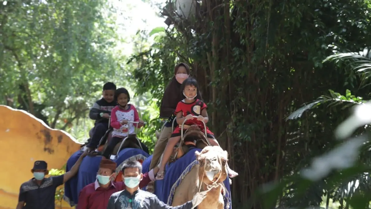 KBS: Anak-anak menikmati wahana tunggang unta di Kebun Binatang Surabaya dengan pengawasan ketat petugas.