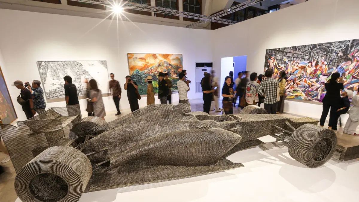 Pengunjung mengamati instalasi seni mobil balap di pameran ARTSUBS 2026, Balai Pemuda Surabaya.