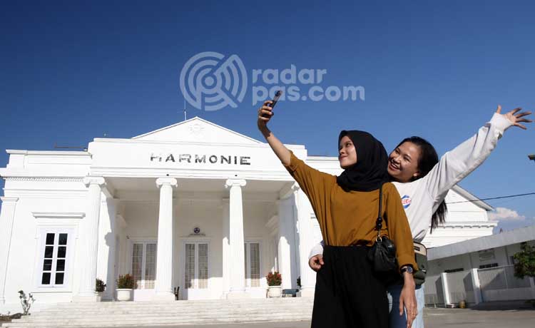 Dua warga berpose di depan Gedung Harmonie Kota Pasuruan, beberapa waktu lalu. (Mokhamad Zubaidillah/ Radar Bromo)
