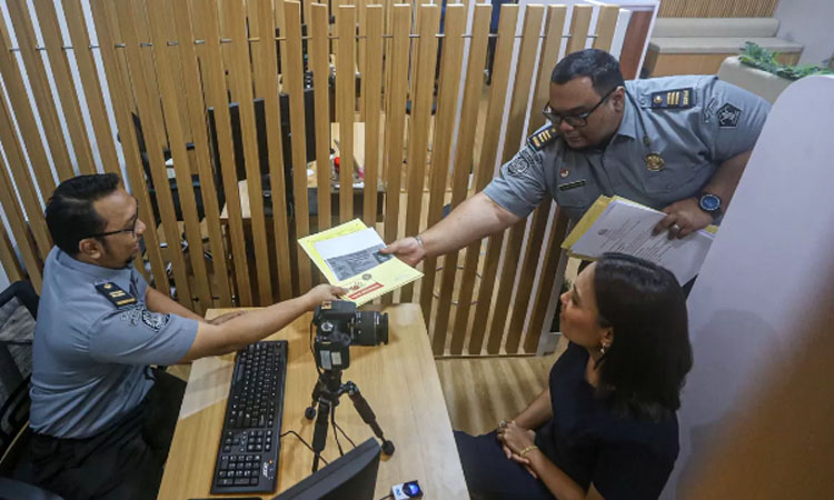 Petugan melayani warga yang mengurus paspor di Ruang Layanan Keimigrasian &ldquo;Immigration Lounge&rdquo; di Senayan City Mall Lt 6, Jakarta Pusat, Senin (30/9/2024). (Jawa Pos)