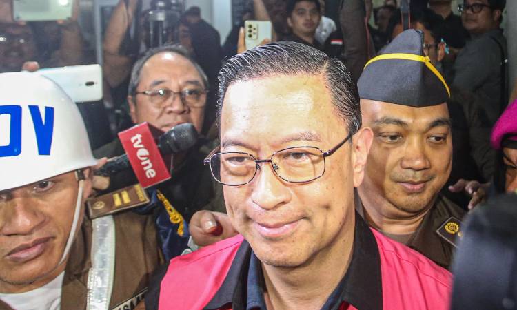 Menteri Perdagangan tahun 2015-2016 Thomas Lembong dibawa menuju mobil tahanan di Kejaksaan Agung, Jakarta, Selasa (29/10/2024). (Miftahul Hayat/ Jawa Pos)