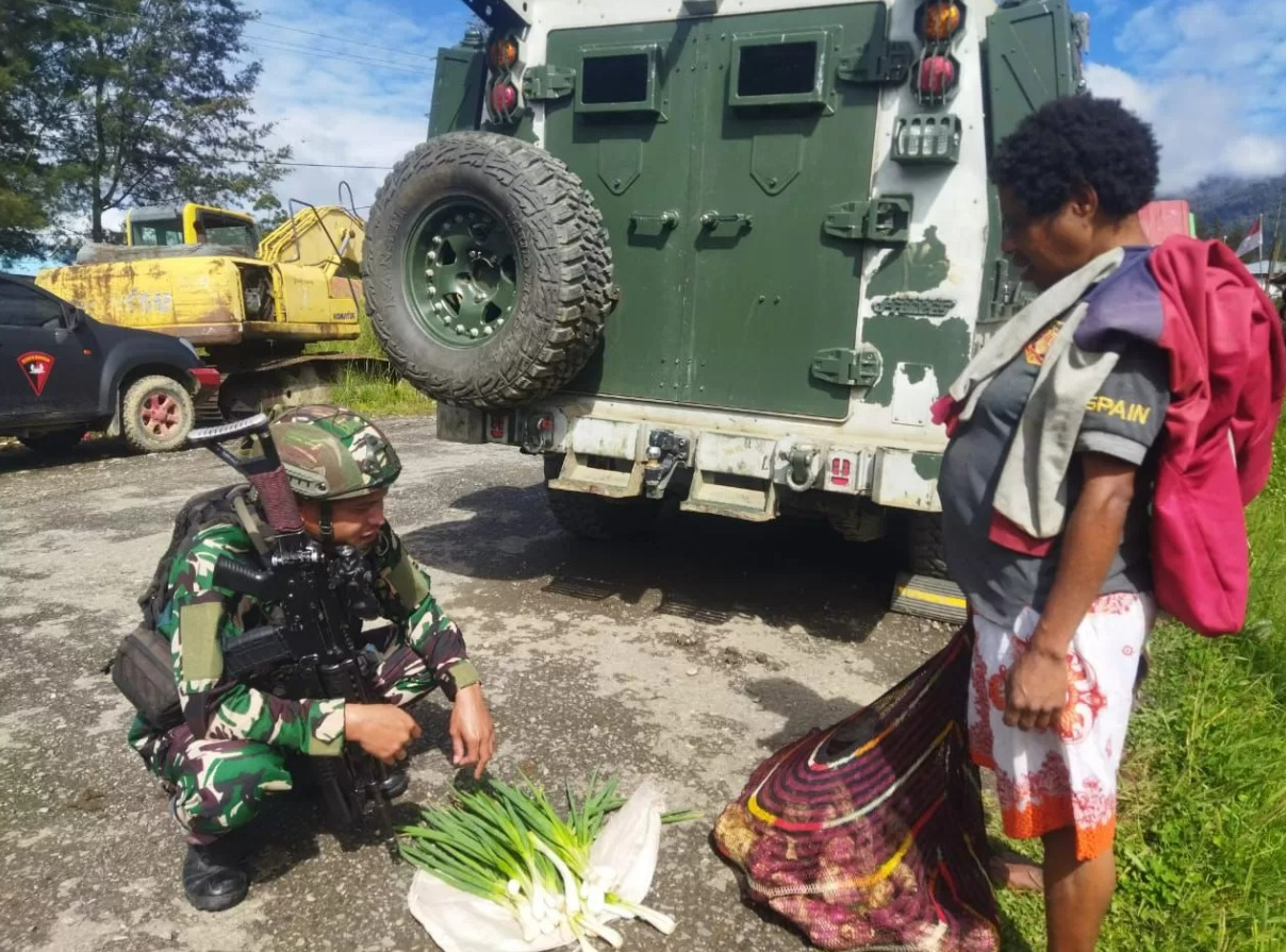 Prajurit TNI dari Satgas Yonif Raider 323/Buaya Putih Kostrad memborong hasil tani warga Kampung Jenggerpaga, Distrik Ilaga, Kabupaten Puncak, Papua Tengah.