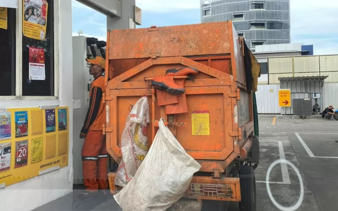 Motor roda tiga pasukan orange isi bensin di SPBU swasta.