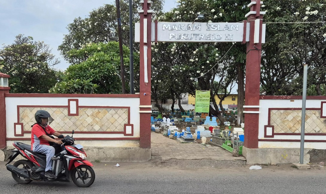 MAKAM ISLAM: Pemotor melintas di gerbang TPU Purutrejo II
