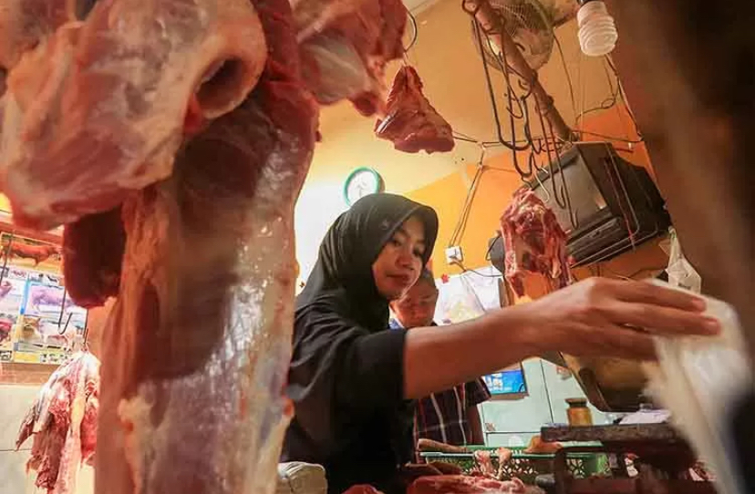BANYAK DIBURU: Pedagang daging di pasar daerah Pasuruan, melayani pembeli. Menjelang Lebaran, permintaan daging meningkat.