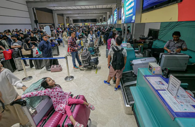 Sejumlah penumpang mengantri di counter check-in Terminal 2, Bandara Soekarno-Hatta, Tangerang, Jumat (28/3/2025).