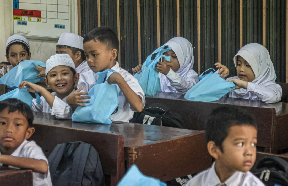 Sejumlah siswa Sekolah Dasar menerima menu Makan Bergizi Gratis (MBG) khusus bulan Ramadhan di SDN 15 Slipi, Jakarta, Senin (10/3/2025).