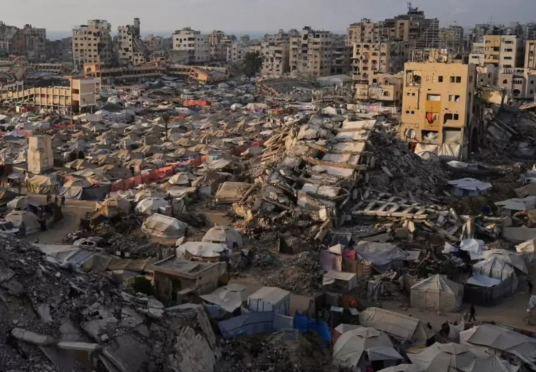 Kamp tenda bagi warga Palestina yang mengungsi membentang di antara puing-puing bangunan yang hancur akibat serangan udara Israel di bagian barat Kota Gaza, Sabtu (21/6/2025).