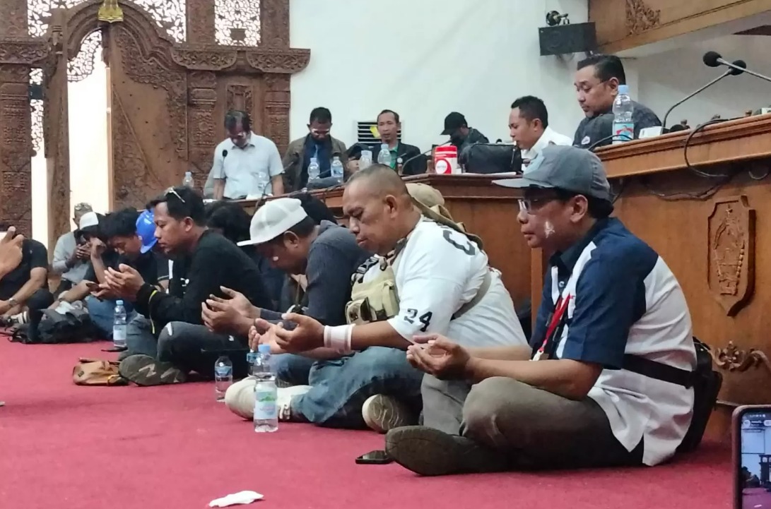 Anggota DPRD Pati dan peserta demo berdoa setelah mendengar kabar dua orang perempuan dan wartawan meninggal dalam demo, Rabu 13/8/2025.