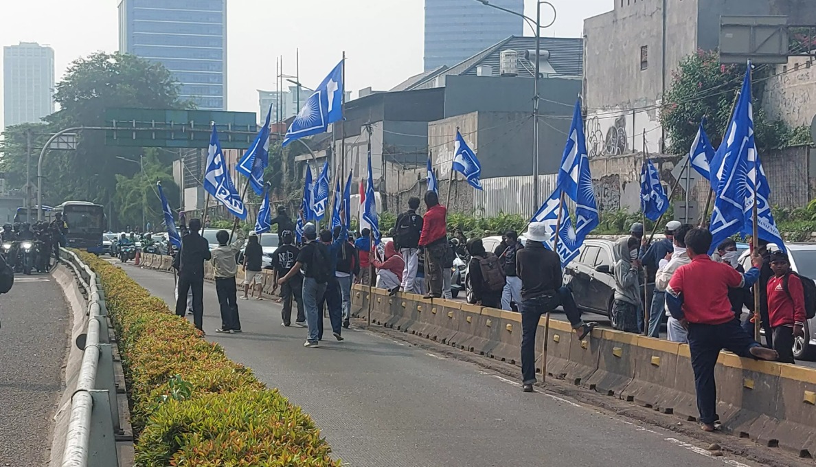 Puluhan massa aksi membawa bendera PAN hingga masuk ke ruas jalan tol dalam kota, saat Demonstrasi 25 Agustus di Gedung DPR RI Jakarta Pusat, Senin (25/8).