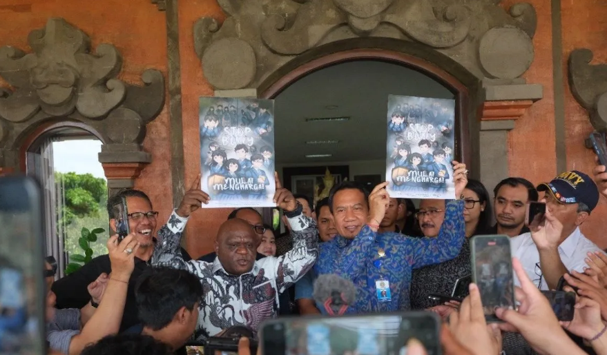 Menteri Hak Asasi Manusia Republik Indonesia Natalius Pigai didampingi Rektor Universitas Udayana Prof I Ketut Sudarsana mengangkat poster berisi kampanye anti perundungan.